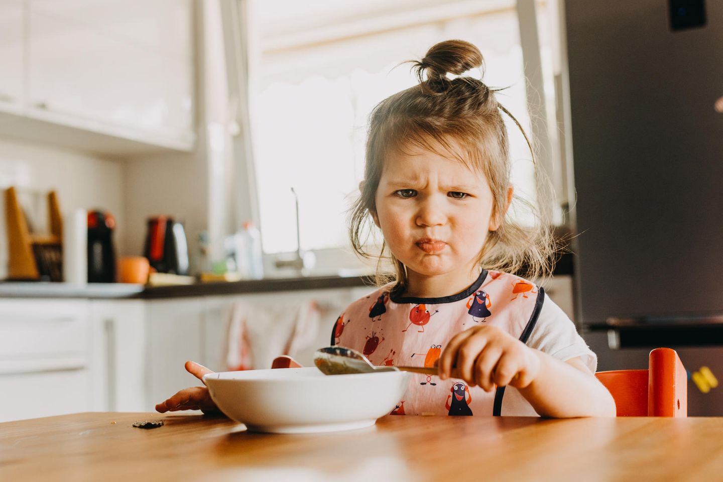 Wenn-dann-Falle: Kleines Mädchen am Esstisch rümpft die Nase