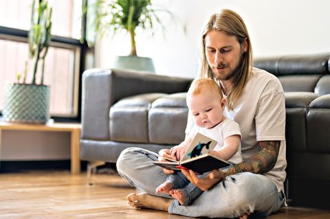 Was passiert, wenn Eltern Babys früh regelmäßig vorlesen? Vater liest seinem Baby etwas vor