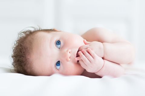 Taufsprüche: süßes blauäugiges Baby mit Fingern im Mund