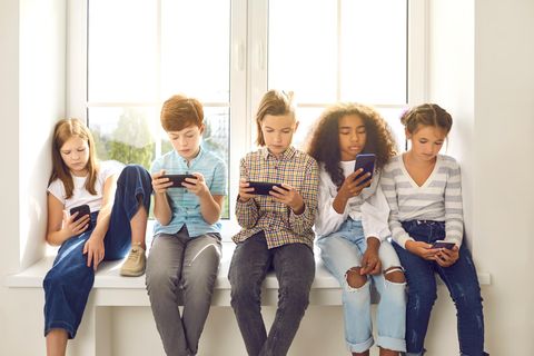 Fünf Kinder schauen gleichzeitig auf ihr Handy
