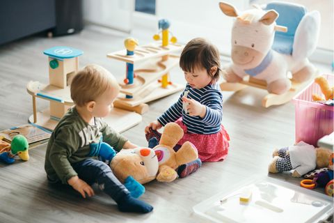 Zwei Kinder spielen in der Kita mit einem Stofftier