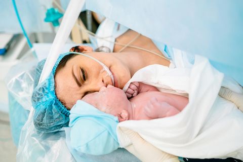 Eine Mutter sieht zum ersten Mal ihr Kind nach einem Kaiserschnitt