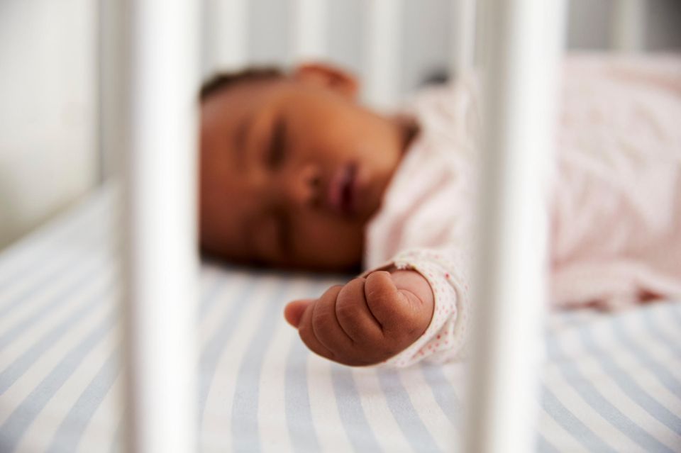 Baby zuckt im Schlaf: Baby schläft im Kinderbett
