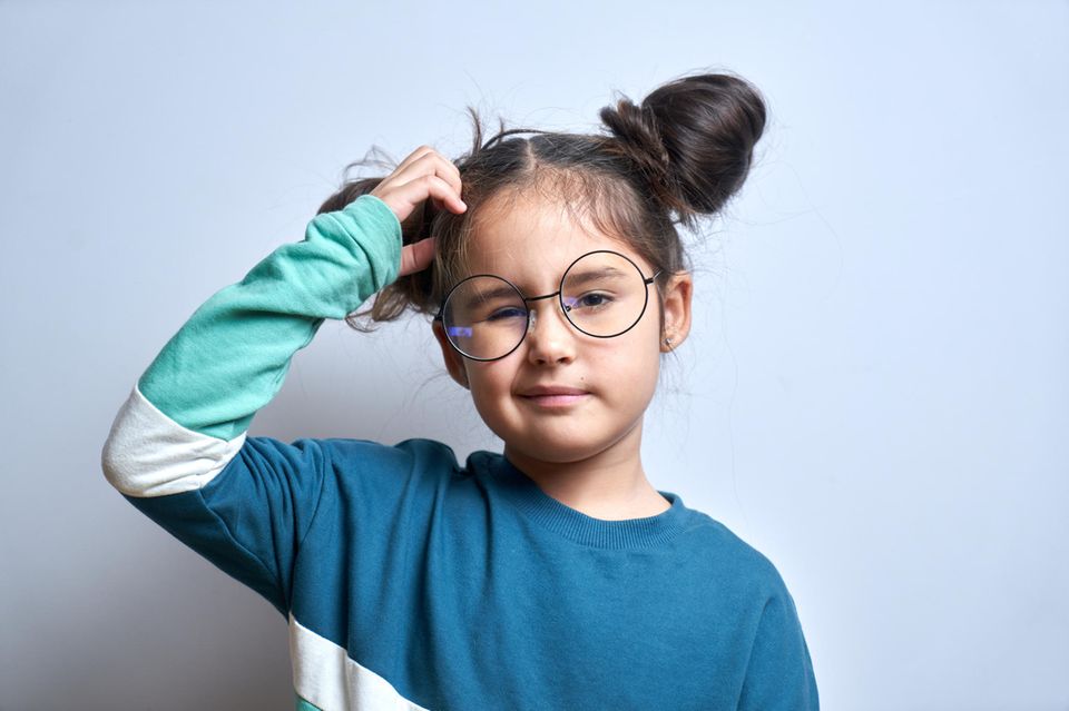 Entscheidungen treffen lernen: Ein junges Mädchen mit Brille kratzt sich fragend am Kopf