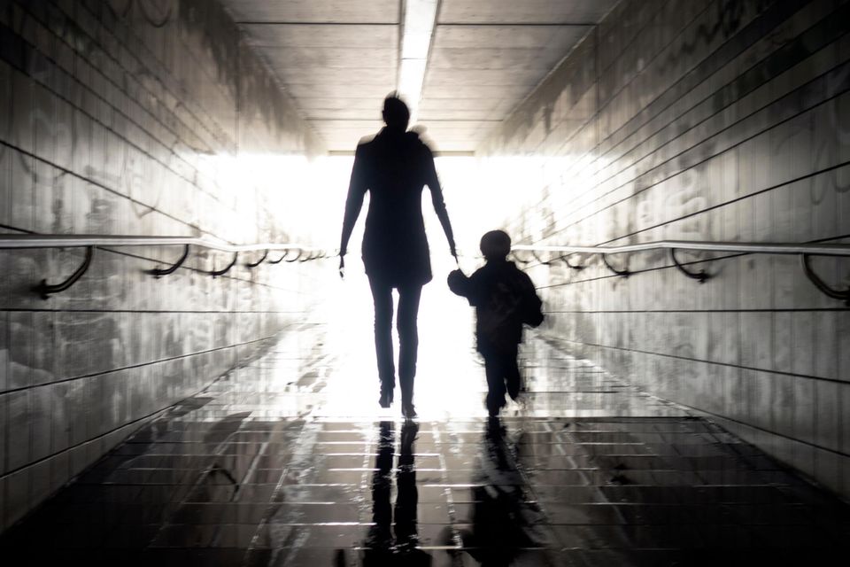 Eine Mutter geht mit ihrem Kind durch einen Tunnel