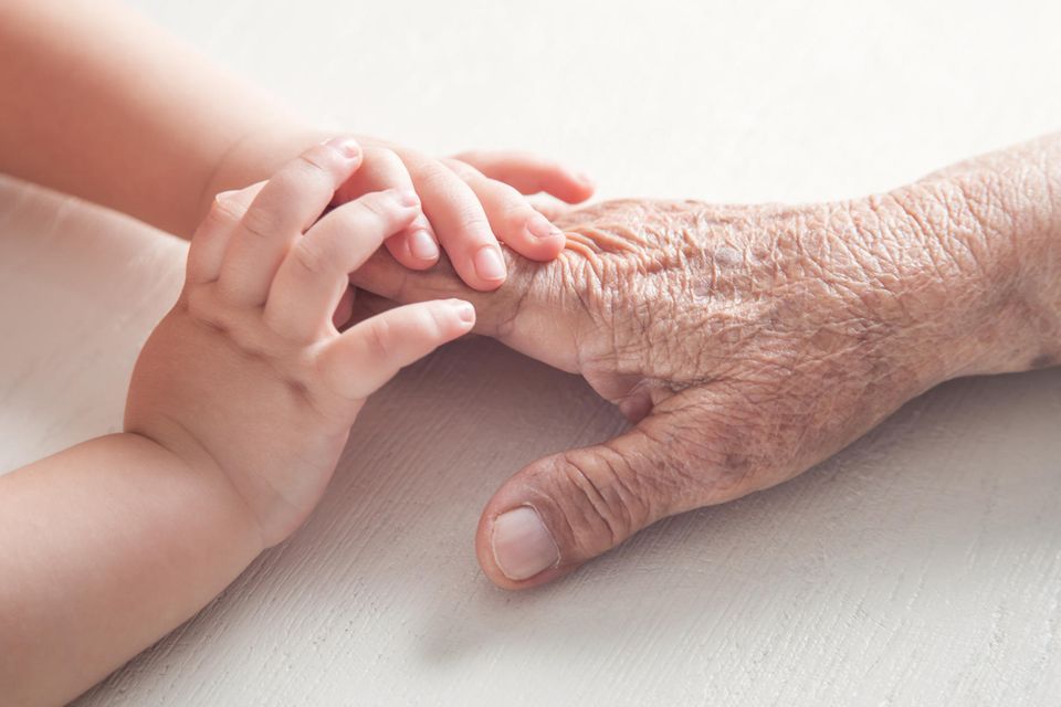 Umgang mit Demenz: Kinderhände liegen auf Händen einer älteren Person