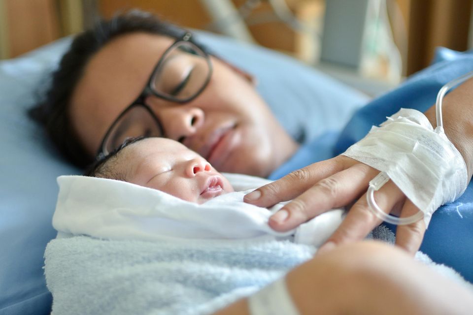 Scheidenriss: Mutter hält ihr neugeborenes Baby im Arm