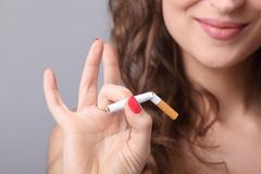 Allergien vorbeugen: Frau schnippt zerbrochene Zigarette mit den Fingern weg