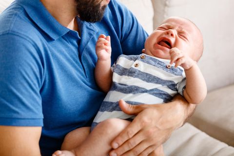 Bauchschmerzen beim Baby: Vater hält weinendes Baby
