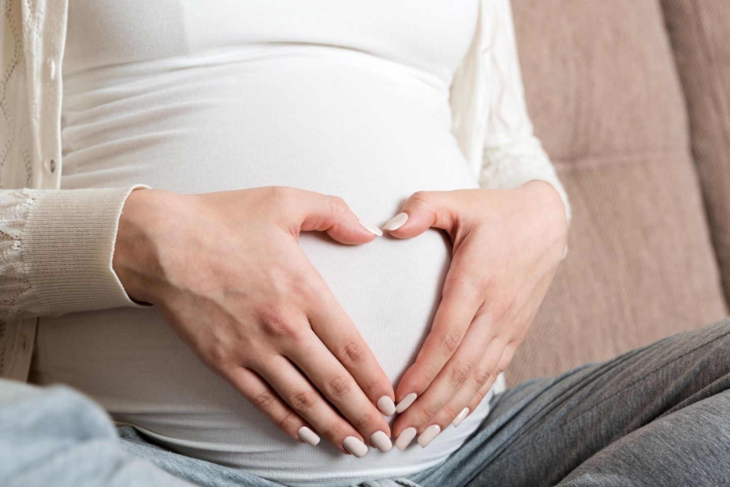 Vorderwandplazenta: Schwangere Person hält die Hände zum Herz geformt vor dem Bauch