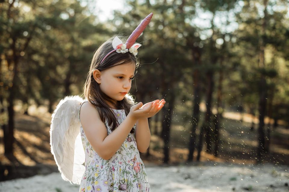 Magische Phase: Ein Kind trägt eine Verkleidung aus Flügeln und Horn auf dem Kopf