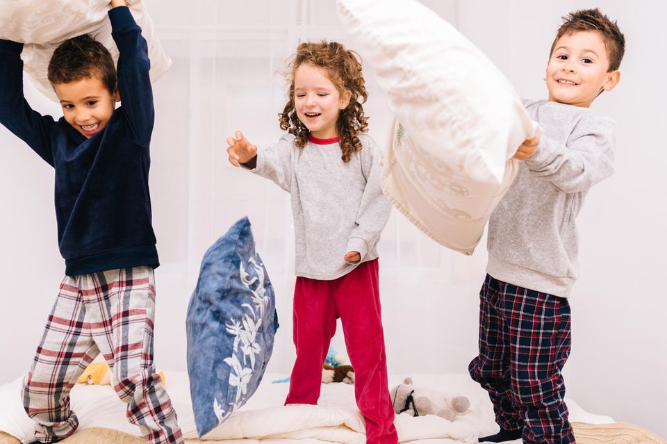 Kinder spielen Kissenschlacht bei Regenwetter