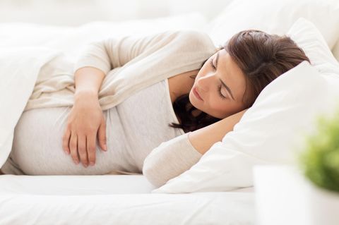 Vena-cava-Syndrom: Schwangere liegt in Seitenlage im Bett
