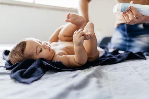 Windelsoor: Person cremt ein Baby beim Wickeln ein