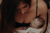 Eigenständige Geburt: Mutter hält Baby nach der Entbindung