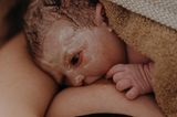 Eigenständige Geburt: Baby saugt an Mamas Brust