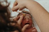 Eigenständige Geburt: Hebamme versorgt das Baby