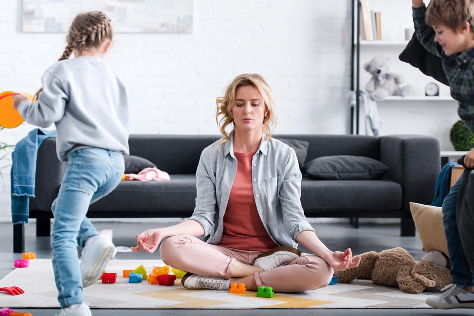 Mutter meditiert inmitten tobender Kinder