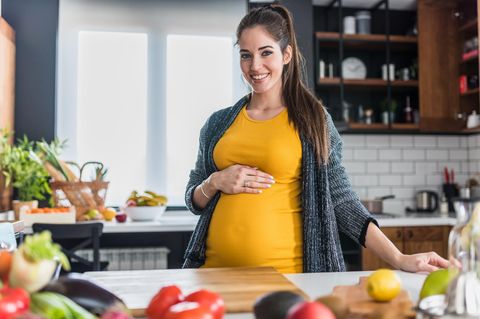 Schwangerschaftsvitamine: Eine Schwangere Frau steht in der Küche