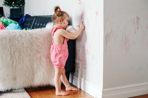 Familienkolumne: Mädchen malt mit roten Stiften die Wohnzimmerwand an