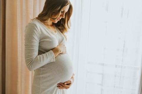 Zeichnungsblutung: Schwangere hält sich den Bauch und schaut nach unten