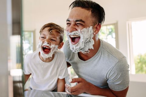Vater und Sohn lachend mit Rasierschaum im Gesicht