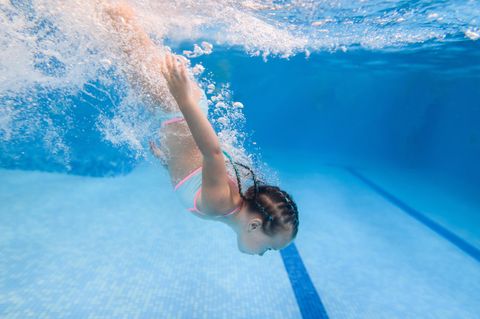 Schwimmabzeichen: Kind taucht unter der Wasseroberfläche in einem Schwimmbad