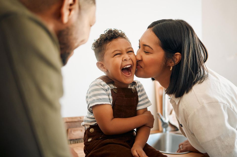 Humor in der Erziehung: Eltern lachen mit ihrem kleinen Sohn