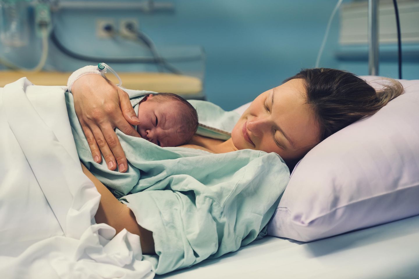 Eine Frau mit ihrem Baby im Krankenhausbett