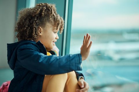 Familienkolumne: Ein kleines Mädchen winkt am Fenster