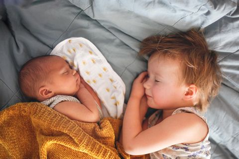 Zu erledigen, wenn das 2. Kind kommt: Kleinkind und Baby schlafen friedlich zusammen im Bett..