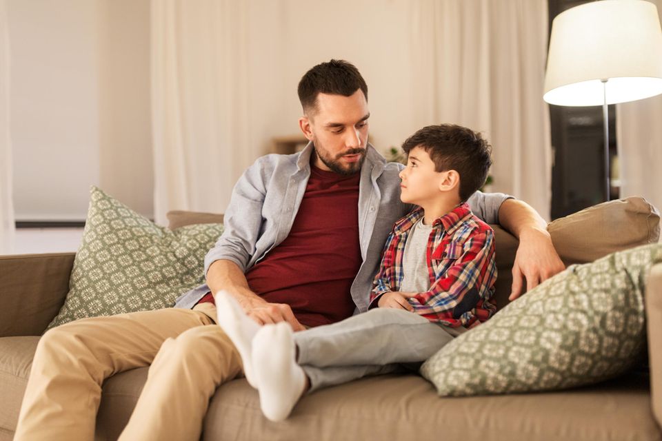 Autoritativer Erziehungsstil: Mann und Junge sitzen auf einem Sofa