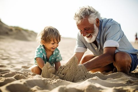 Die schönsten Sommererinnerungen: Opa baut mit seinem Enkel eine Sandburg