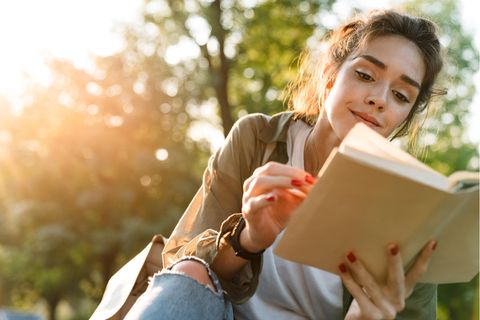 Jugendbücher: Frau liest ein Buch unter freiem Himmel