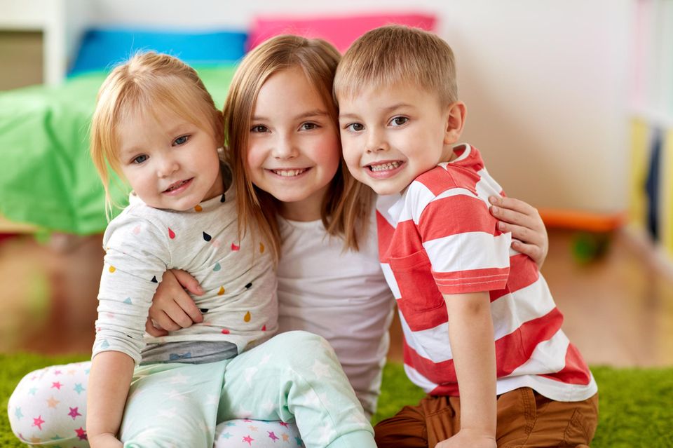 Drei Geschwister im Spielzimmer