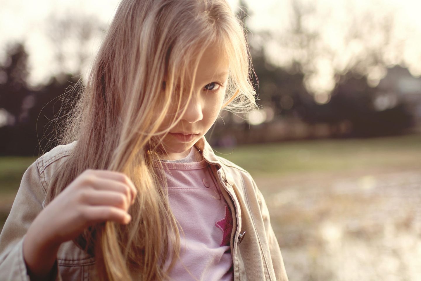 Rapunzel-Syndrom: Kind mit langen Haaren im Gesicht blickt in die Kamera