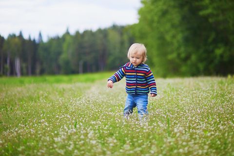 Finnische Jungennamen: Kleiner Junge läuft über eine Wiese