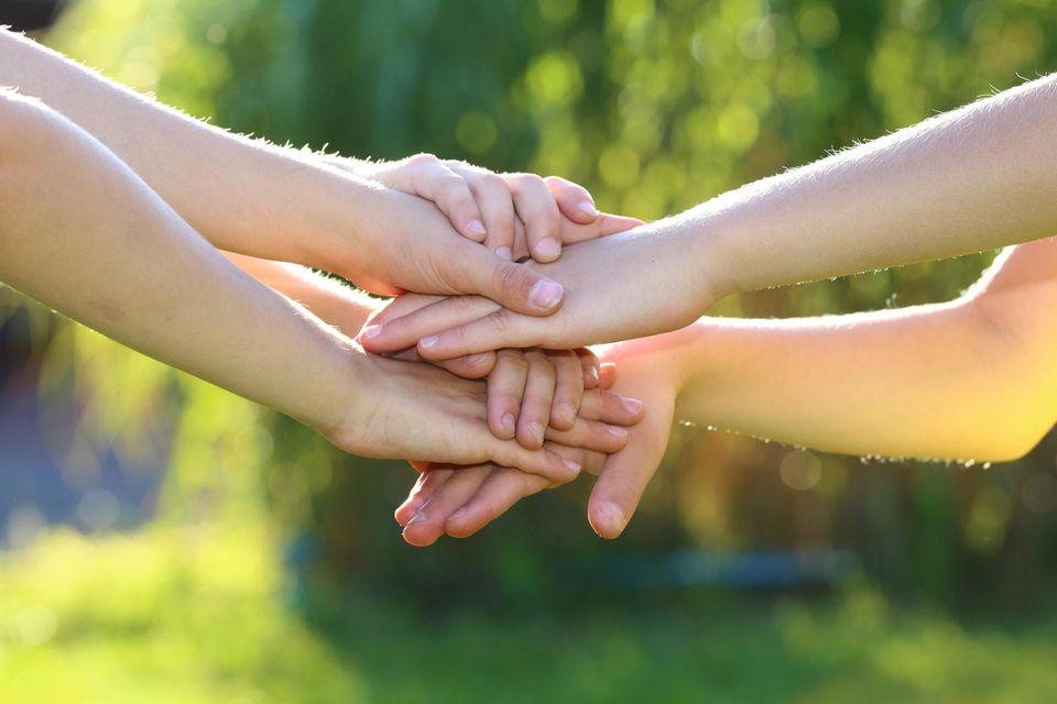 Familienregeln für Zusammenhalt: viele Hände liegen aufeinander