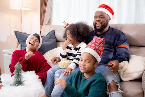 Lustige Weihnachtsfilme: Familie sitzt gemeinsam auf Couch