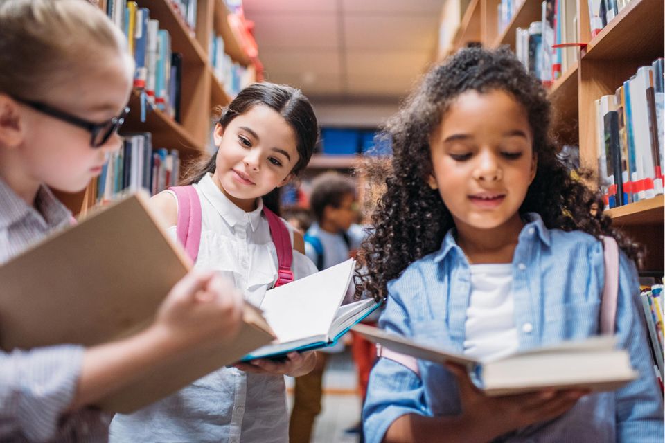 Deutscher Kinderbuchpreis 2023: Schulkinder schauen sich interessiert Bücher an
