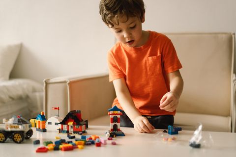 Prime Day Lego-Angebote: Glücklicher Junge spielt mit Lego-Steinen