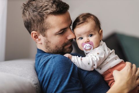 Schnuller auskochen: Papa hält Baby im Arm