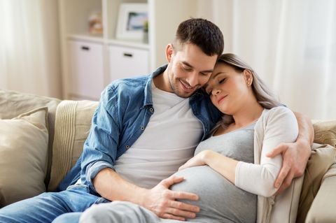 Die letzten Tage vor der Geburt: Mann hält schwangere Frau im Arm