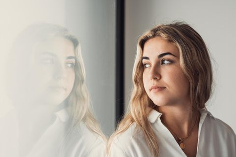 PCO-Syndrom: Junge blonde Frau schaut nachdenklich aus dem Fenster