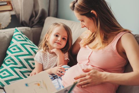 Geschwisterbücher: Schwangere Mama liest mit ihrem Kleinkind ein Buch