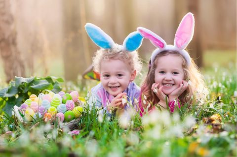 Ostersprueche: Zwei Kinder mit Hasenohren auf einer Wiese