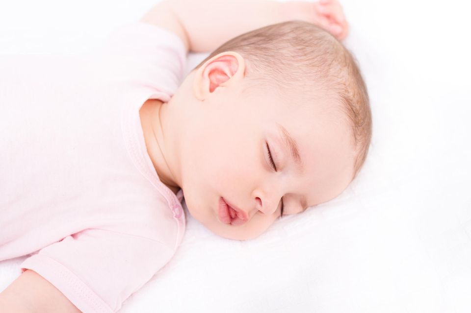 Atemüberwachung beim Baby: Süßes schlafendes Baby in rosa Body