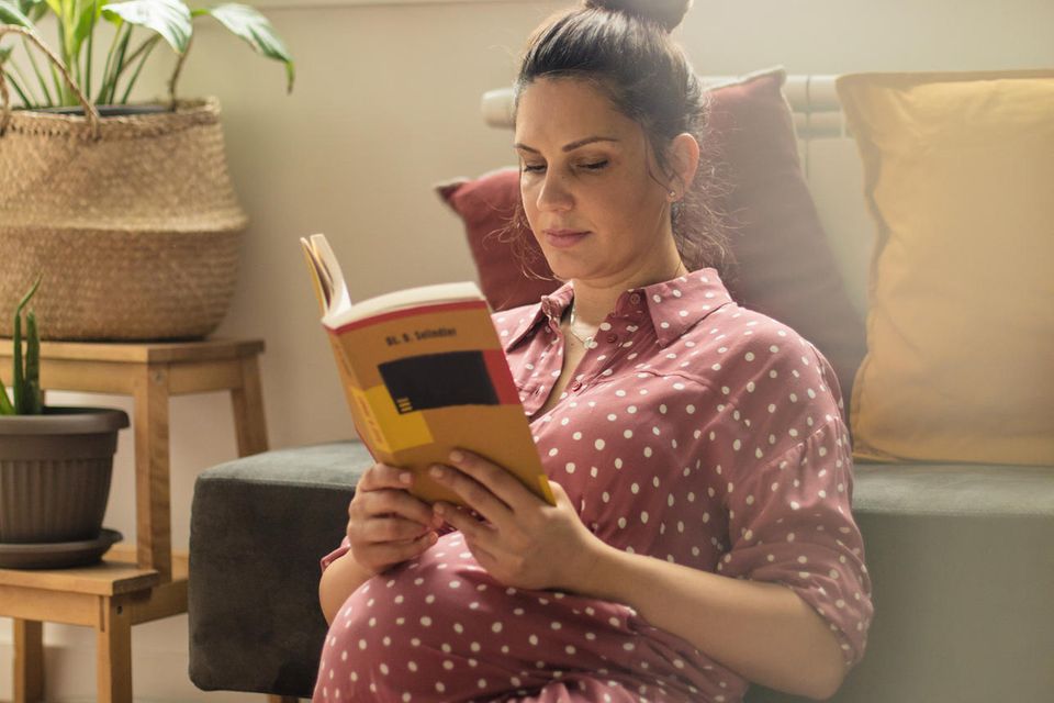 Schwangerschaftsbücher: Schwangere Frau liest ein Ratgeberbuch