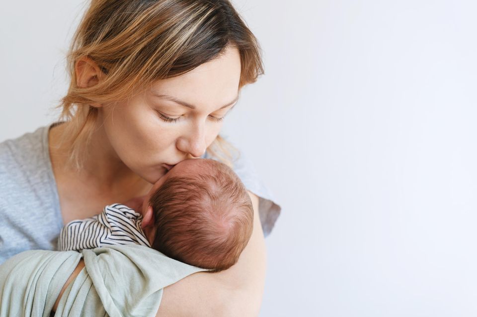 Geschenke für Mütter zur Geburt: Frischgebackene Mama mit Säugling auf dem Arm
