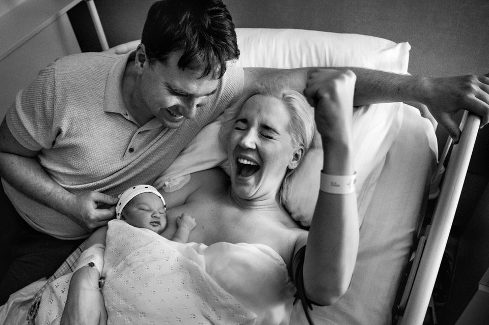 Geburtsfotografie 2024: Jubelnde Frau mit Neugeborenem